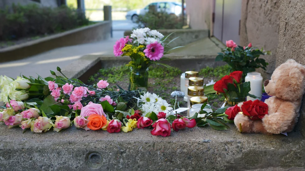 Karlskrona 2014: Blommor, ljus och en nalle utanför porten till det hus där den åttaåriga flickan som mördades bodde. Arkivbild.