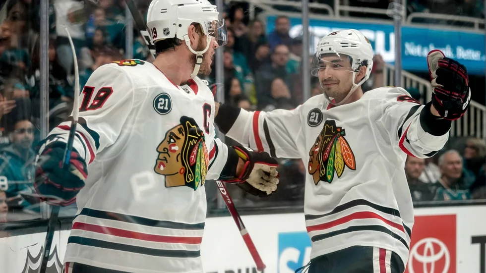 Dylan Sikura, till höger, jublar med NHL-ikonen Jonathan Toews.