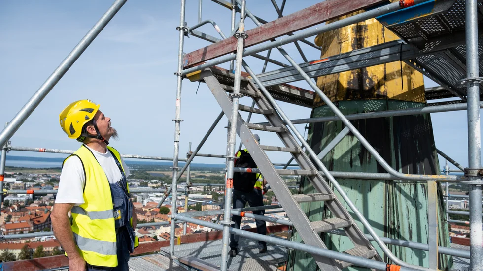 Den åtta meter höga guldspiran är högre än man kan tro när man ser den från marken. Plåtslagare Niclas Bylund får böja ordentligt på nacken för att se hela.