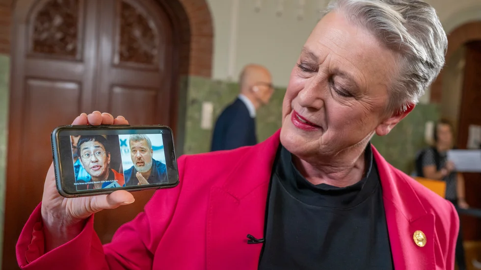 Berit Reiss-Andersen, ordförande för Nobelkommittén, visar en bild på årets fredsprisvinnare,  journalisterna Maria Ressa och Dmitrij Muratov.
Foto: Heiko Junge / NTB