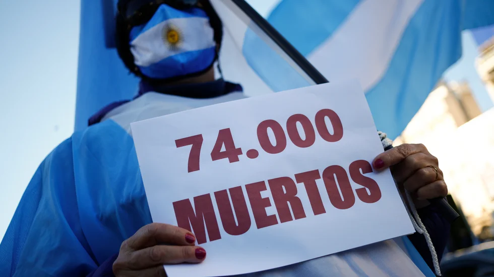 "74|000 döda". En man protesterar mot den argentinska regeringens hantering av covidpandemin.