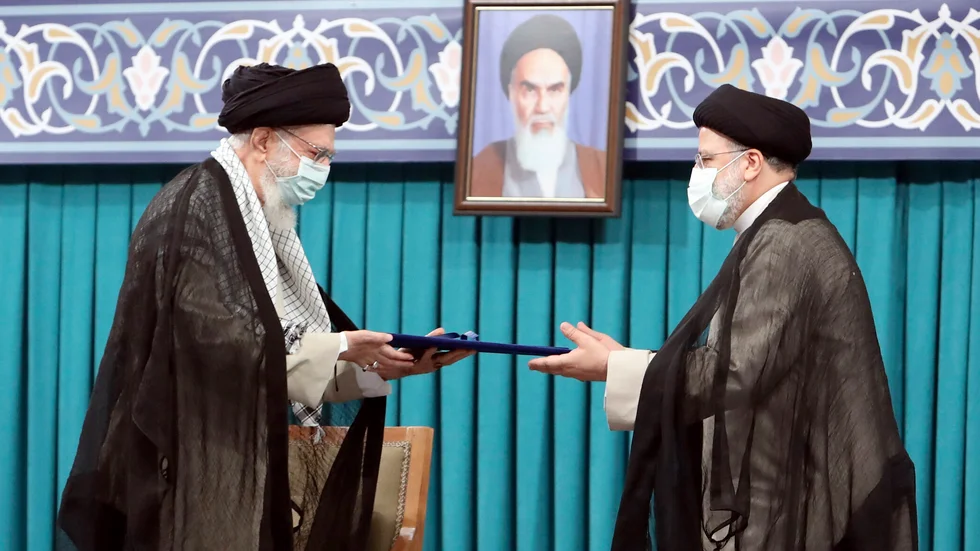 Irans högsta ledare Ayatollah Ali Khamenei (till vänster) ger sitt officiella godkännande till landets nya president Ebrahim Raisi vid en ceremoni i huvudstaden Teheran.