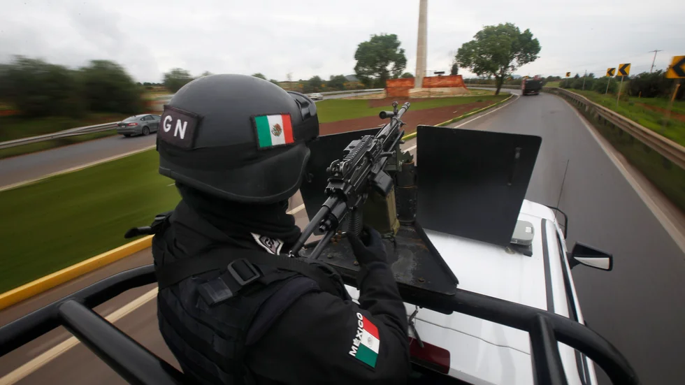 En soldat bevakar en motorväg i delstaten Zacatecas i centrala Mexiko efter en rad attacker från drogkarteller i juli. Arkivbild.