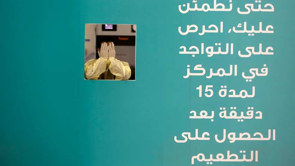 En vårdanställd vid ett vaccinationscenter i Jidda i Saudiarabien tar en paus. Bilden är från i maj.
