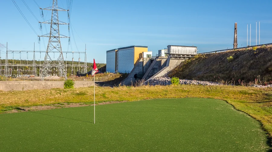 Porjus golfbana med nio hål nära gamla kraftstationen. I bakgrunden skymtar ställverket som ska byggas ut.
