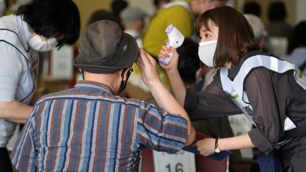 Kroppstemperatur kollas vid ett vaccineringscenter i Tokyo på måndagen.