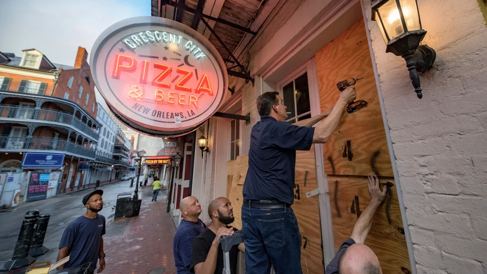Personal på en pizzeria i New Orleans stormsäkrar lokalen inför orkanen Idas ankomst.