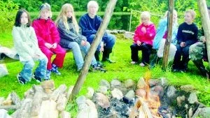 Runt elden. Barnen som kom till prova på scouting-kvällen fick lära sig att tända en eld vid Finspångs scoutkårs stuga och därefter samlades man runt brasan.