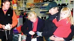 Pappa Jan Kraemer håller Camille på höften medan mamma prövar skridskon. Marcus Persson kommer med tips och förslag, tyvärr inte med en skridsko i rätt färg och storlek, de är slutsålda.
FOTO: GUNNAR JOHANSSON
