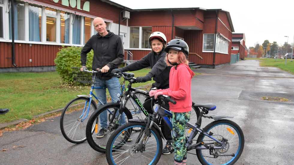 Daniel Åberg med barnen Tage och Ejda utanför skolan. Båda barnen påverkas av skyddsstoppet.