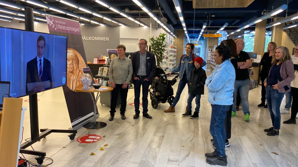Bibliotekarie Sofia Larsson, enhetschef Ola Gustafsson och flera andra intresserade följde tillkännagivandet av Nobels litteraturpris via en tv-skärm i Stadsbiblioteket i Norrköping.