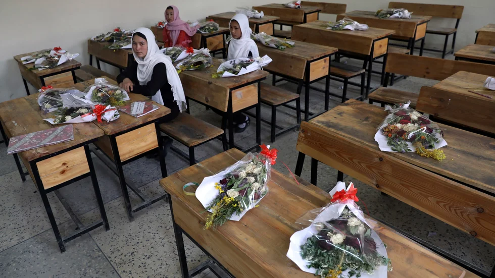 Flickor i en skola i Afghanistans huvudstad Kabul med blommor på de bänkar där klasskamrater som dödats suttit. Arkivbild.