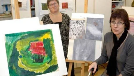 BESVIKNA. Ing-Marie Grönlund och Helen Wallin visar upp varsin målning som de har gjort i Råd och stöds skapargrupp. Båda två är besvikna över att verksamheten läggs ned.