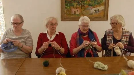Vera B Holmström, Sylvia Granström, Minette Berger och Hilda Engman är några av de som stickat tjocksockor och tröjor till Introduktionsprogammet.