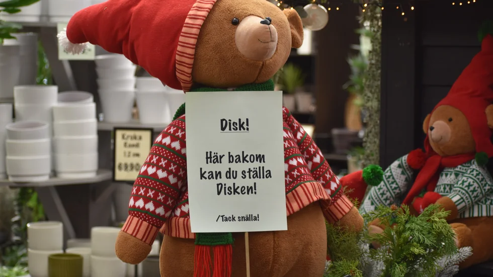 En julbjörn informerar cafégästerna om vad som gäller efter att fikat är slut.