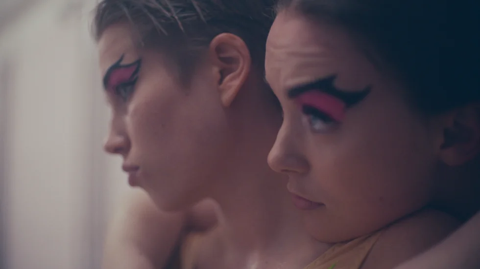 Marion och Marit (Thea Sofie Loch Næs och Amalia Holm) drömmer om att bli konstsimmare. Men när en intim video från en fest sprids på nätet faller livet i bitar.