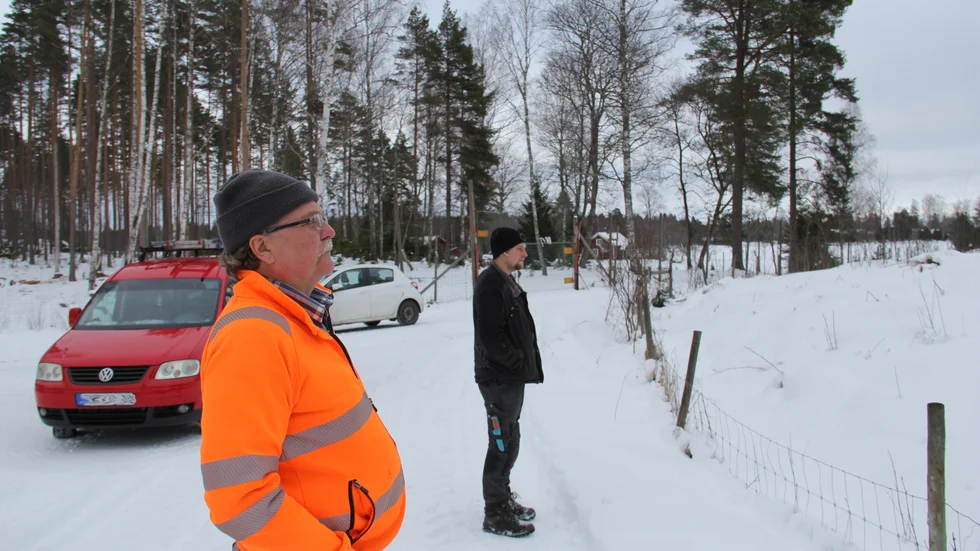 Lars Jansson blickar tillsammans med sonen Viktor ut över fårhagarna som riskerar att växa igen om fåren försvinner.