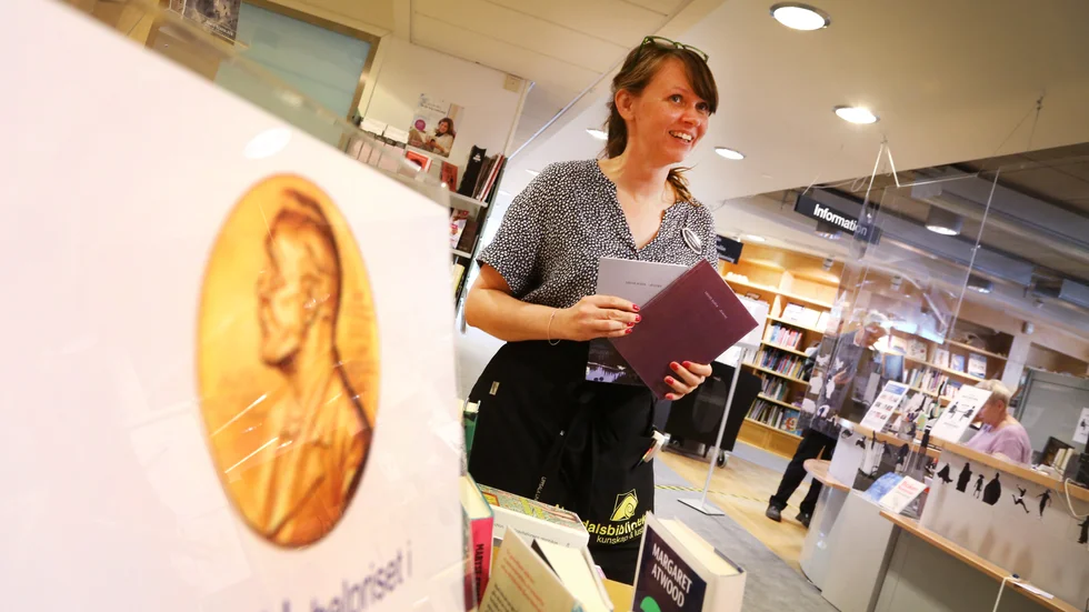 Bibliotekarien Rose-Marie Larsson Cedendahl gläds åt Nobelpristagaren och plockar snabbt fram Louise Glücks två böcker som finns på Almedalsbiblioteket.