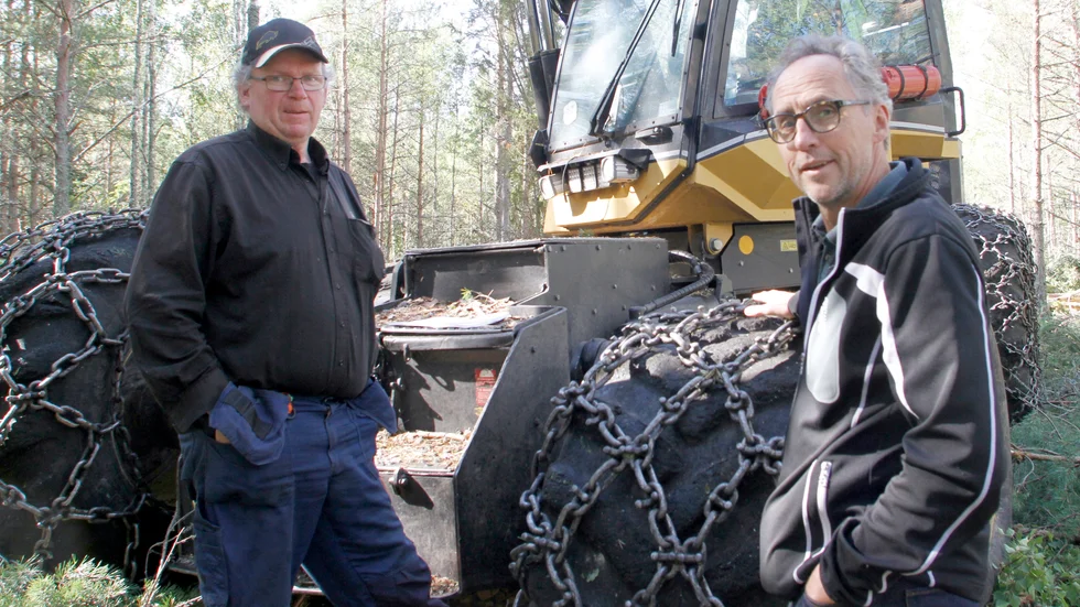 Markförvaltaren Peter Nyström i samspråk med Mikael Grönlund, som kör en skogsmaskin av typen skördare.