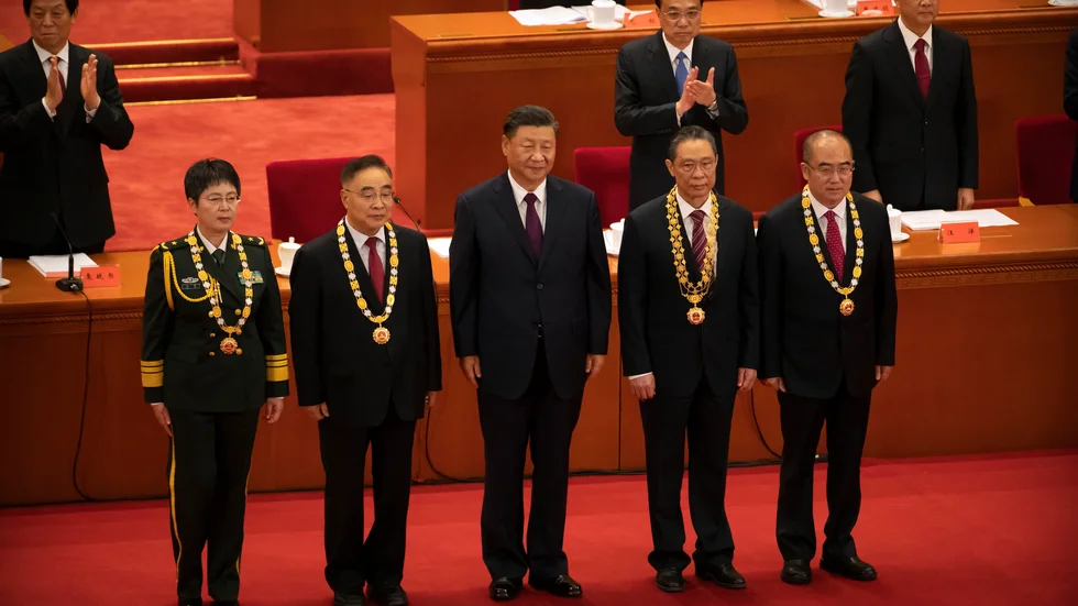 Kinas president Xi Jinping, i mitten, tillsammans med medicinska experter under ceremonin i Folkets stora hall i Peking på tisdagen.