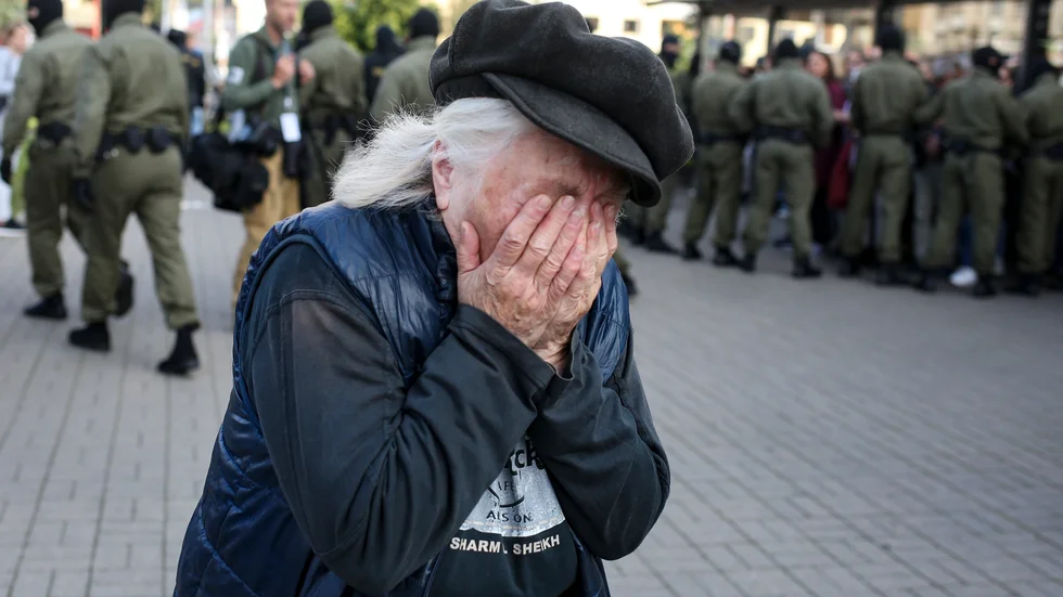 En äldre kvinna reagerar på polisens bortföranden av demonstranter under lördagens protester i Minsk, Belarus.