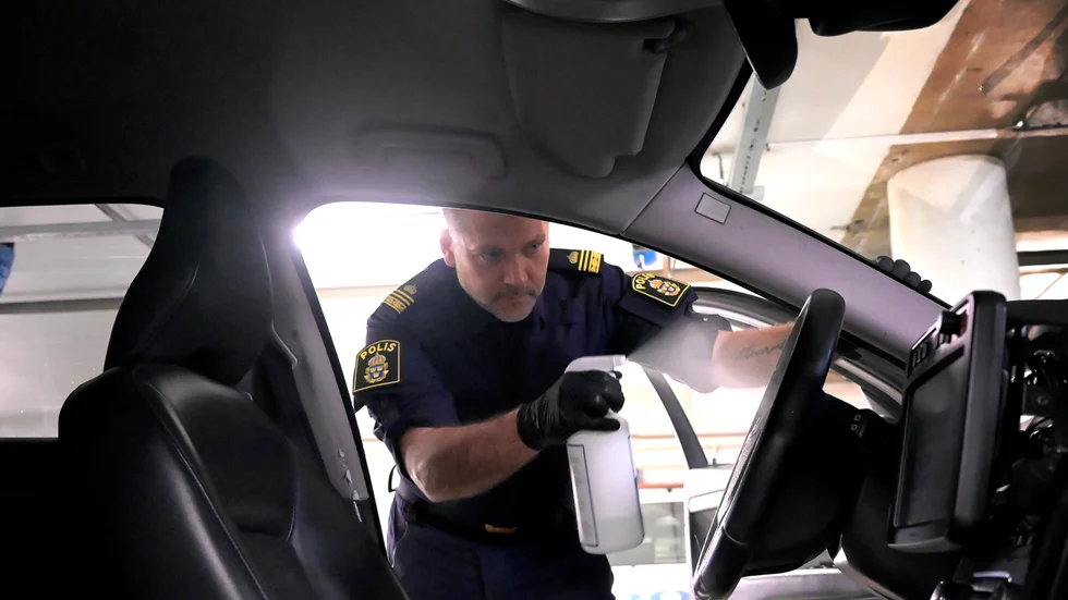Poliserna Pär Lundh, yttre befäl på Farsta polisstation, sanerar en polisbil efter ett uppdrag. Arkivbild.