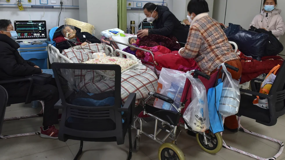 Familjemedlemmar sköter om äldre släktingar med covidsymtom på ett sjukhus i Fuyang i provinsen Anhui.