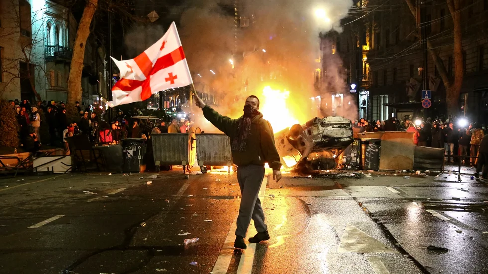 En demonstrant med en georgisk flagga i Tbilisi natten till torsdagen, före de nya beskeden om lagen.