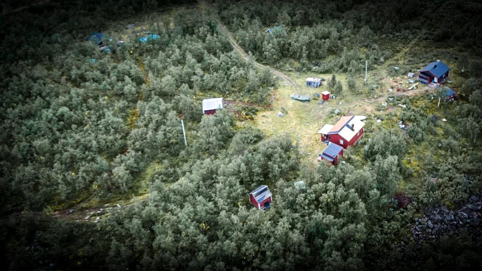 Bråket ska ha börjat i en stuga innan kvinnan flydde till stugan intill, som fick ett skotthål i ytterdörren.