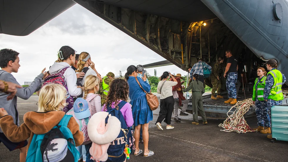 Turister från Australien och andra länder på väg in i planet som lämnade Nya Kaledonien på tisdagen. Bilden har tillhandahållits av det australiska försvarsdepartementet.