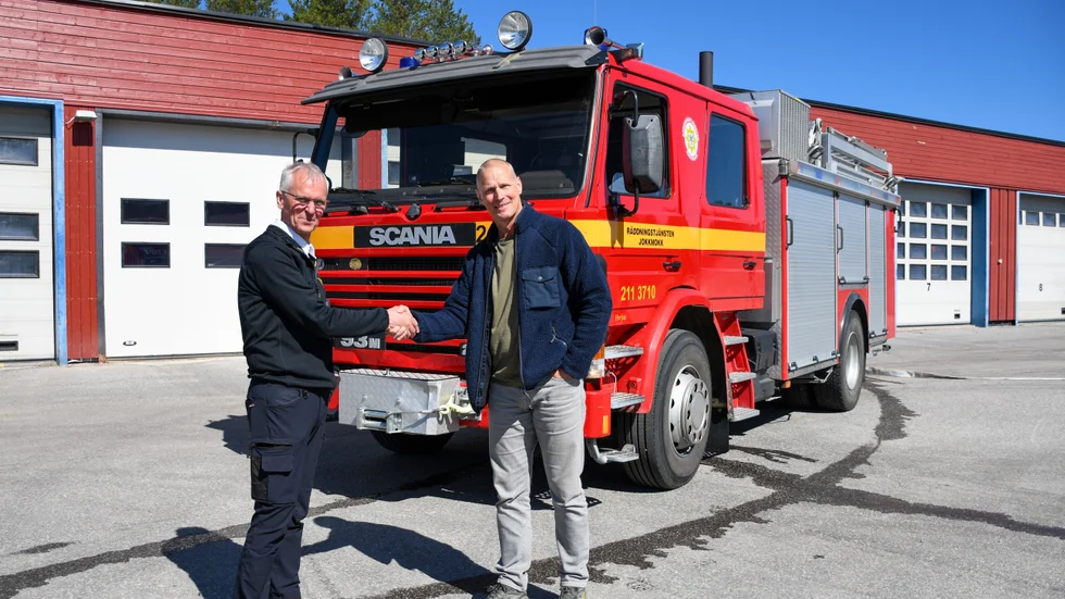 Räddningschef Kaj Nyström skakar hand med Stefan Nilsson från Brandmän för Ukraina framför brandbilen som skänktes.