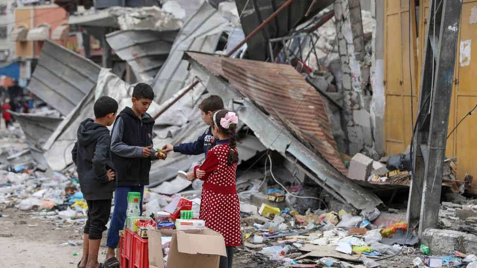 Palestinska barn framför en förstörd byggnad i Gaza. Arkivbild från i november.