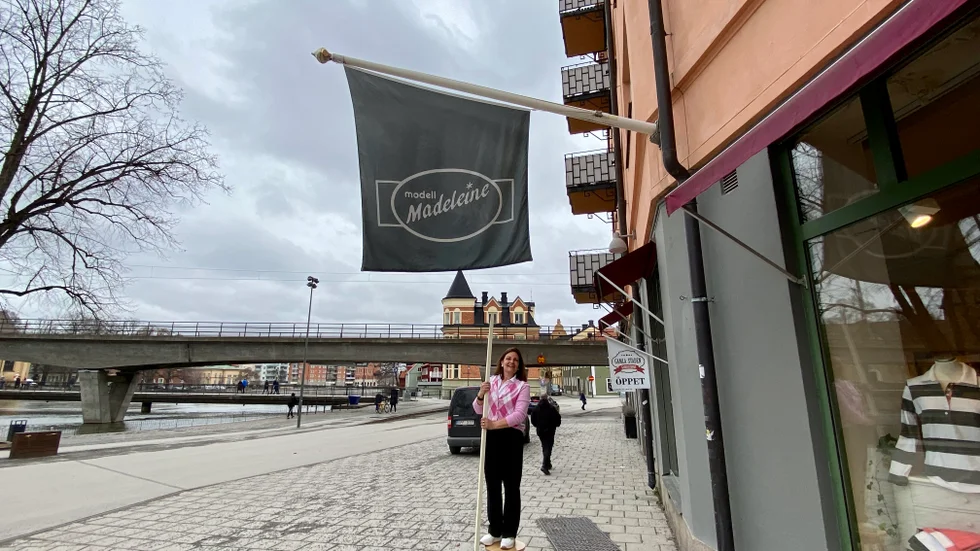 "Här får man göra allt själv", säger Ann Berglund och skrattar innan hon petar ner butiksflaggan som snurrat till sig.