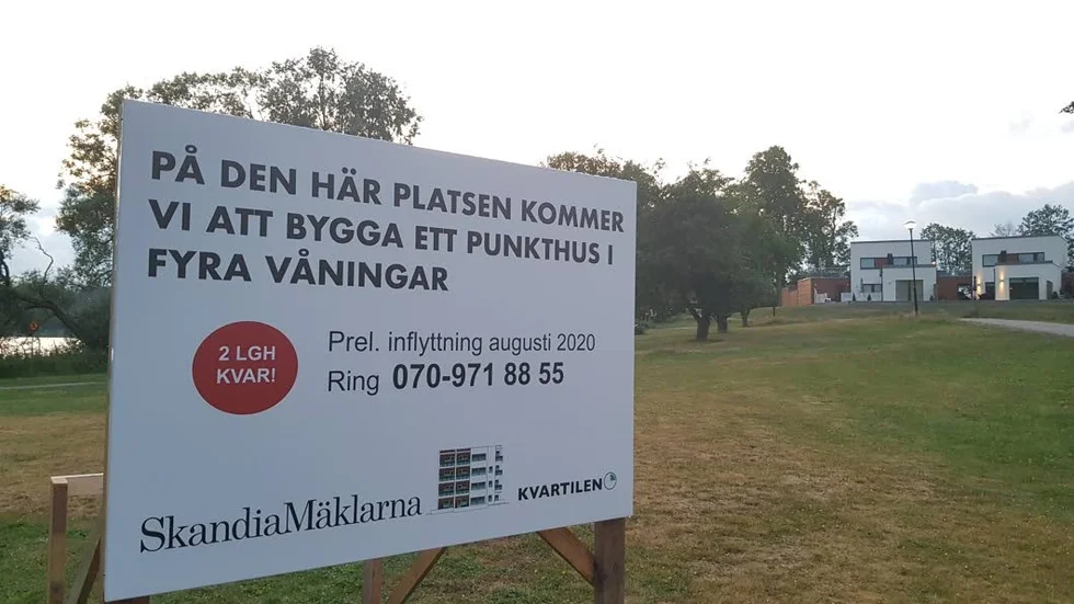 En skylt på Bysjöstrand anger att ett punkthus i fyra våningar ska byggas och att preliminär inflyttning sker i augusti nästa år.