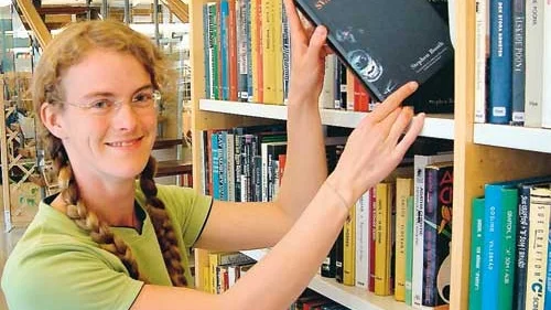 Mia Mårtensson bland deckare och spänningsromaner i stadsbiblioteket i Vimmerby.