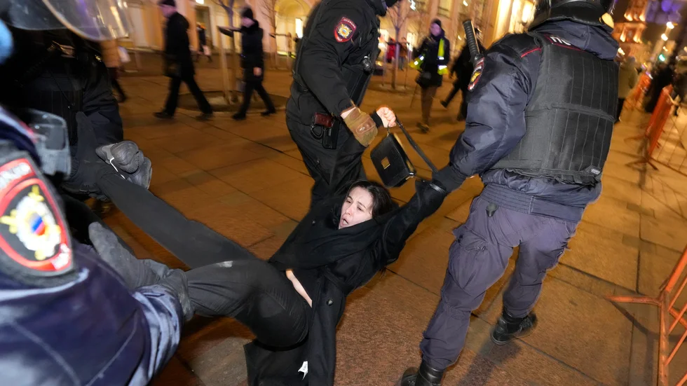 Rysk polis i S:t Petersburg griper en demonstrant som på onsdagen protesterar mot den ryska invasionen i Ukraina.