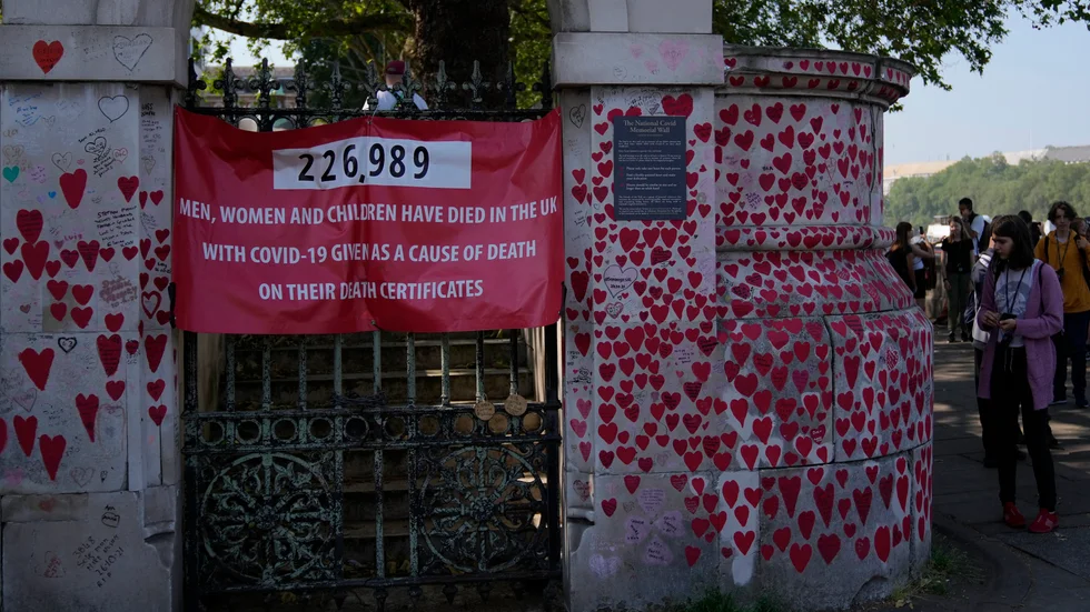 Turister går förbi minnesmonumentet "The National Covid Memorial Wall" i London, som är tillägnat de britter som dog under coronapandemin.