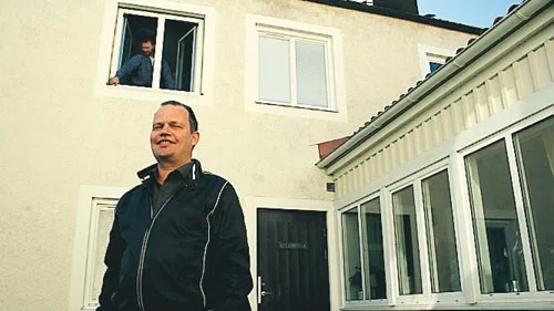 Magnus Wirensjö gläds åt samarbetet Rosén och Johansson och fönstertillverkaren Leiab inlett, vilket gagnar båda de lokala företagen. Fredrik Stejdahl monterar in ett fönster i bakgrunden på Folkhögskolan i Mariannelund där ett omfattande renoveringsarbete pågår.