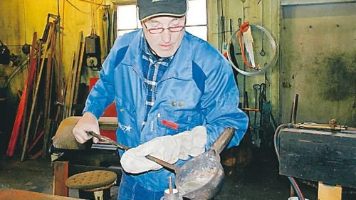 Sven-Eric Svensson är i full färd med att hälla i smält metall i ett gammalt lager för att ge det ett nytt slitlager.