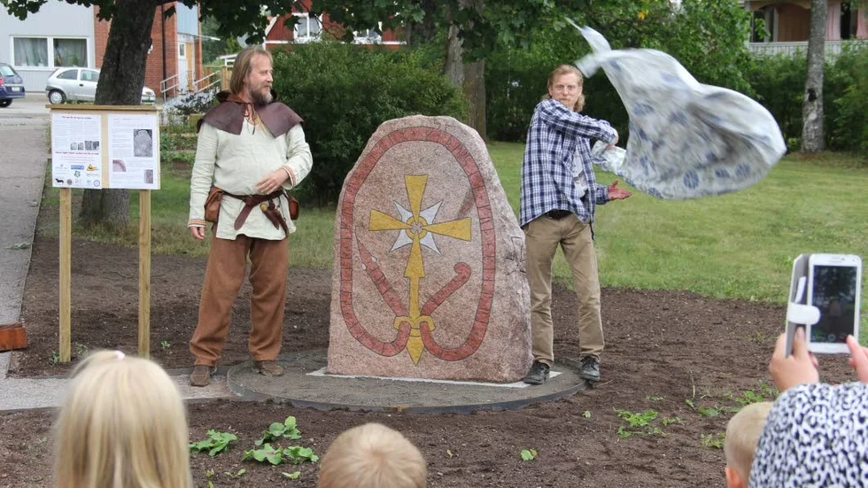 Tillbaka efter 227 år. Mannen bakom runstenskopian, Mats Köbin, avtäcker den i närvaro av Kalle Runristare samt ortsbor.