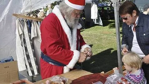 Nemi Larsson som kommit med mormor Margareta Larsson till marknaden i Östhammar på lördagen var tveksam till att låta sig bli bjuden på korv av tomten själv, Gunnar Löfgren från Jokkmokk.