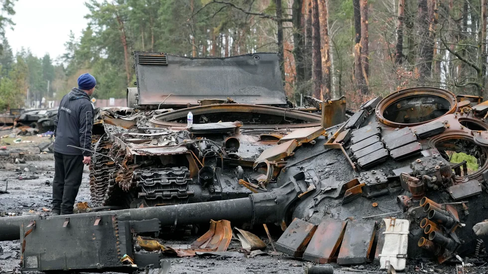 En invånare i Dmytrivka tittar på ryska stridsfordon den 2 april.