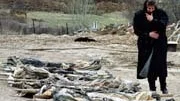En bosnienserbisk kvinna passerar mänskliga kvarlevor som grävdes fram i Mrkonjic Grad 1996.