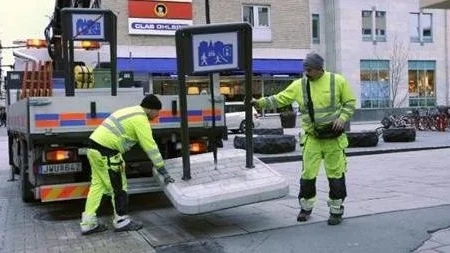 Arivid Lindén t.v. och Jimmy Larsson placerar ut de nya gåfartsskyltarna på Dragarbrunnsgatan.
