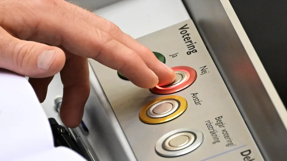 Riksdagsledamot röstar nej under en votering i riksdagen.