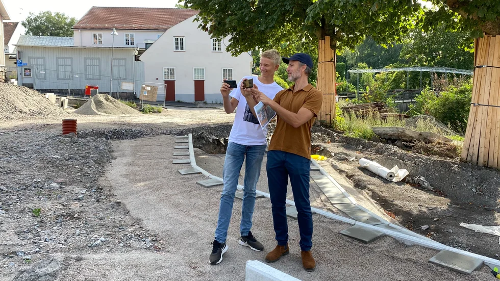 Sebastian Ahlman och Carl Wellander testar appen som ska visa hur Åkroken sett ut historiskt. I telefonen kan man se hur det såg ut i den riktningen man håller kameran.