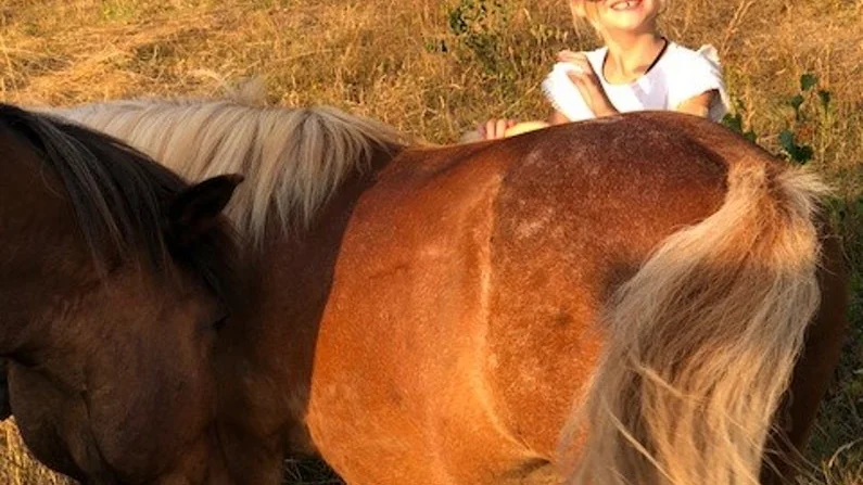 Victoria Cleverling är lika glad som hästarna i kvällsljuset.