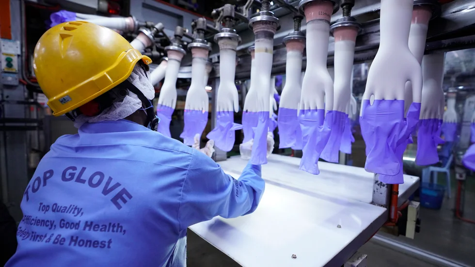 En arbetare kontrollerar skyddshandskar tillverkade vid Top Gloves fabrik i Shah Alam i utkanten av Malaysias huvudstad Kuala Lumpur. Arkivbild.