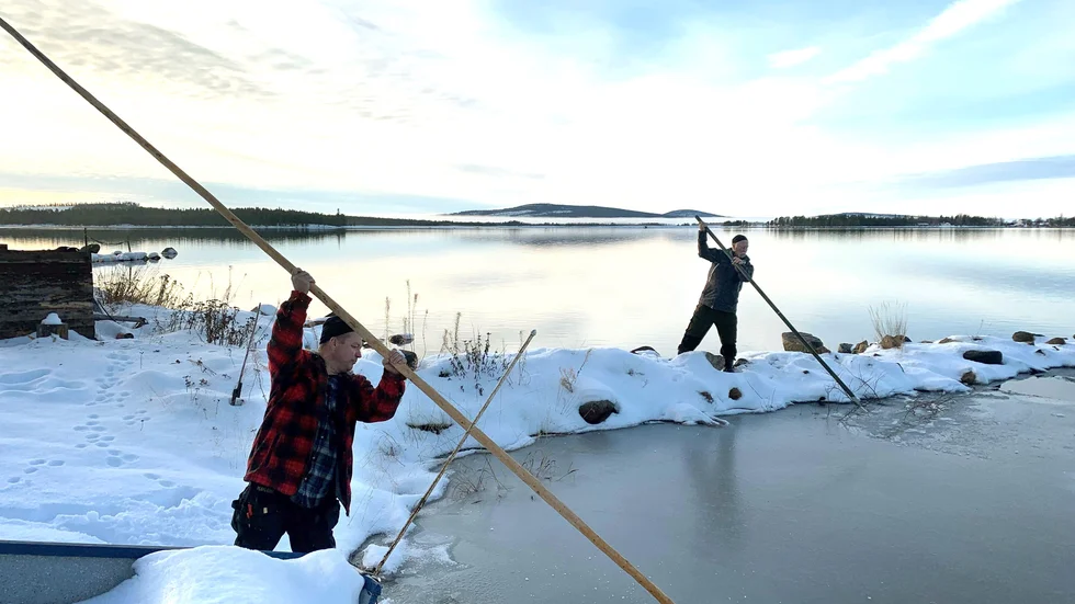 Patrik och Benny kämpar med att få bort isen så att de kan lägga ut fiskenäten.