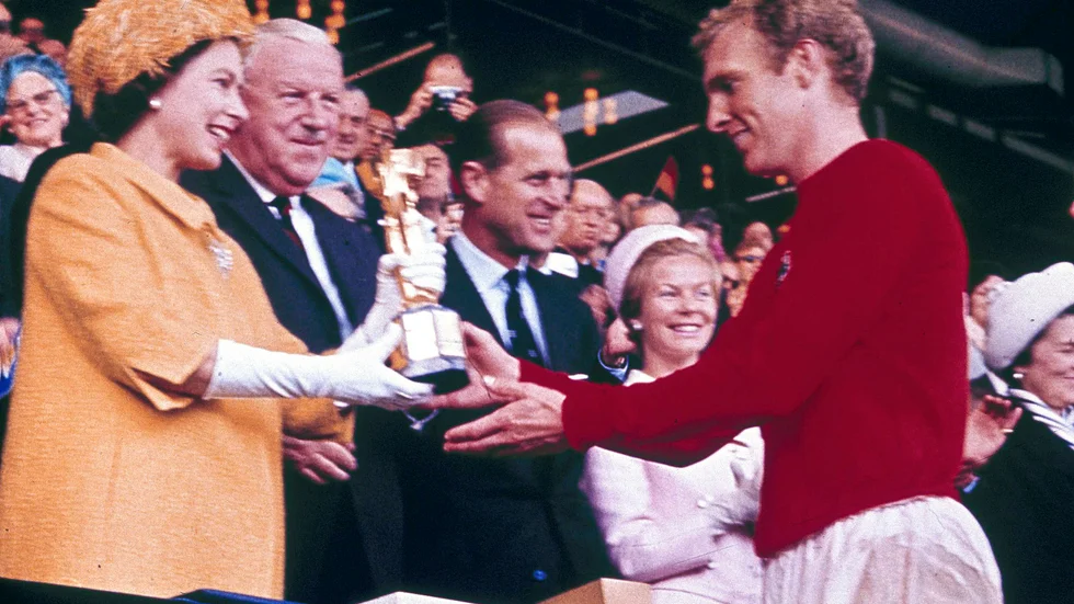 Storbritanniens drottning Elizabeth II överlämnar VM-pokalen till Englands lagkapten Bobby Moore 1966. Nu hoppas drottningen på en ny engelsk titel.